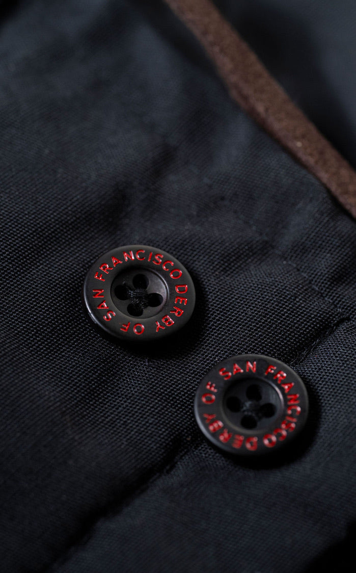 Close-up of black buttons with red text on a dark fabric background