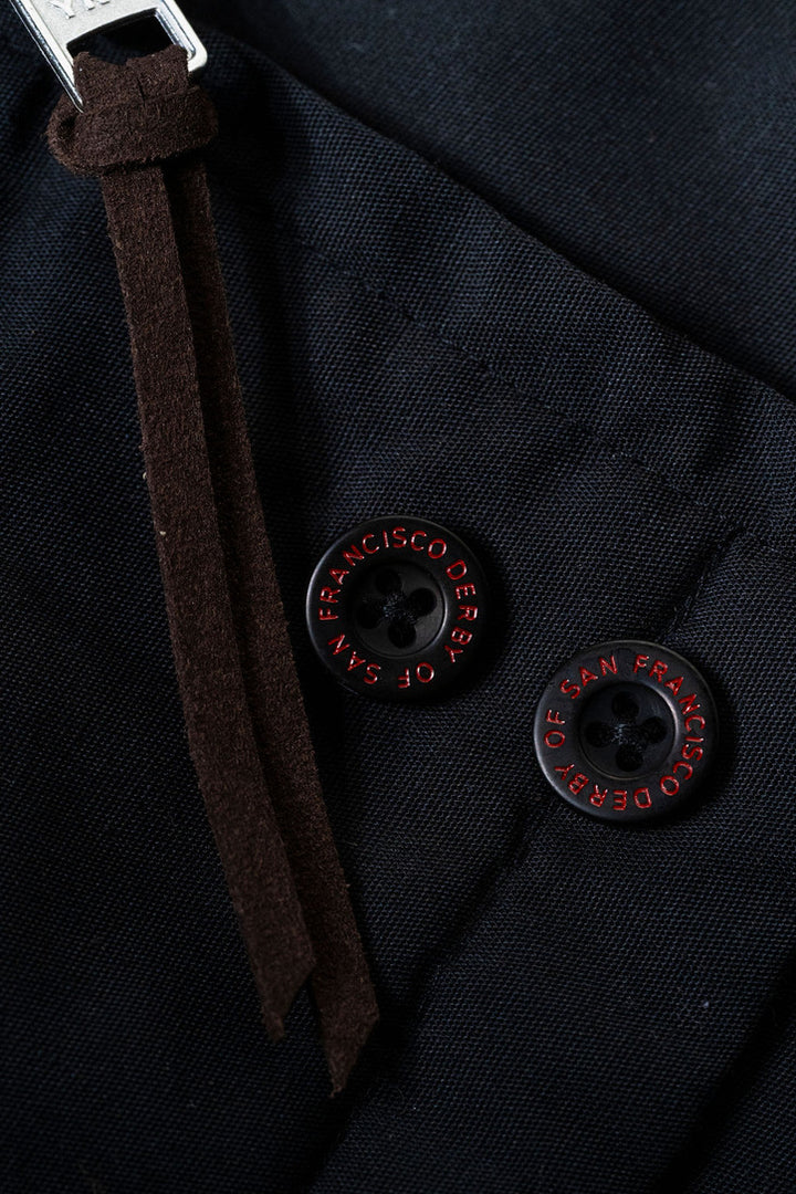 Close-up of a dark fabric surface with buttons and a strap.