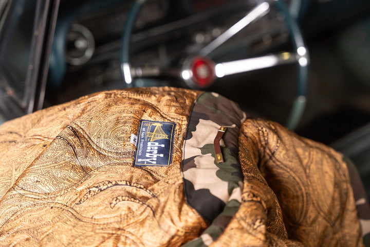 Close-up of a leather glove with a brand label on a vintage car interior background