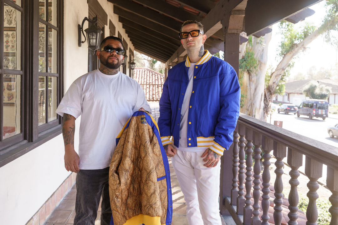 Two men standing on a porch with one holding a jacket