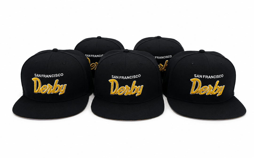Five black flat-brim snapback caps arranged in a row on a white background, each embroidered with &