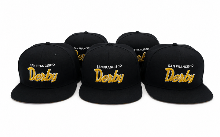 Five black flat-brim snapback caps arranged in a row on a white background, each embroidered with &