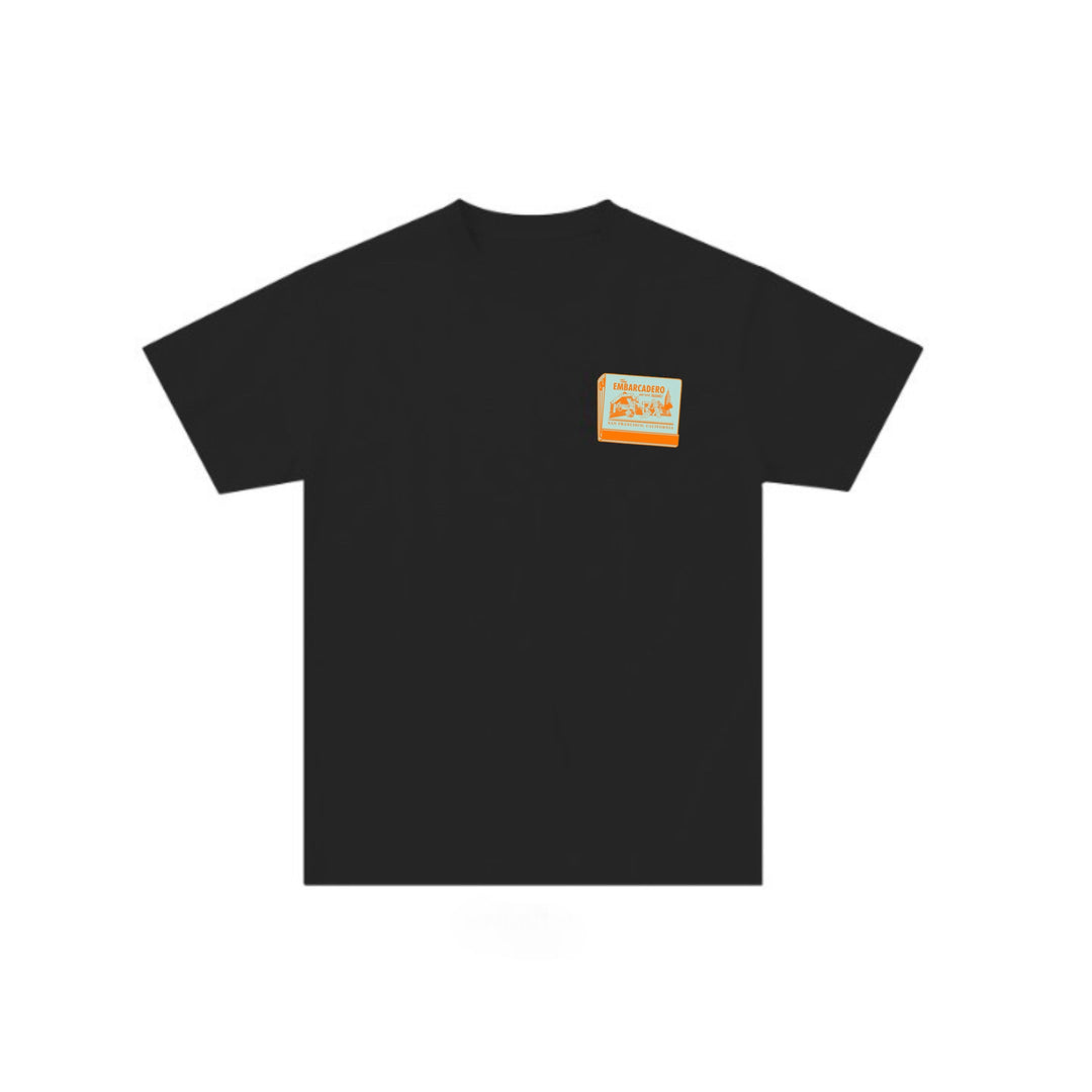 Black t-shirt with a small orange logo on the chest against a white background